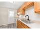 Bright kitchen features wood cabinets, stainless steel sink, and a white door leading outside at 2601 Fairhaven Dr, Indianapolis, IN 46229