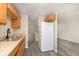 Well-lit kitchen showcasing wood cabinets, modern flooring, and white refrigerator at 2601 Fairhaven Dr, Indianapolis, IN 46229