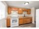 Cozy kitchen with wood cabinets, white appliances, and modern flooring at 2601 Fairhaven Dr, Indianapolis, IN 46229