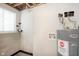 Basement utility area features water heater and laundry hookups next to concrete block wall at 2601 Fairhaven Dr, Indianapolis, IN 46229