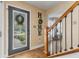 Inviting foyer with hardwood floors, decorative 'HOME' wall art, and a view of the front yard at 272 Van Buren St, Greenfield, IN 46140
