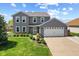 Charming two-story home with a well-manicured lawn, beautiful landscaping, and a two-car garage at 272 Van Buren St, Greenfield, IN 46140