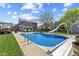 Backyard features a bright blue in-ground pool with slide, ladder, and plenty of patio seating at 272 Van Buren St, Greenfield, IN 46140