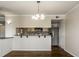 Inviting living room with hardwood floors, classic chandelier, and bar top view into the kitchen at 3127 E 52Nd St # C, Indianapolis, IN 46205