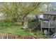 Backyard featuring a large tree, green grass, and stairs leading to a deck at 3432 Joan Pl, Indianapolis, IN 46226