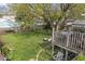 Backyard featuring a large tree, green grass, and stairs leading to a deck at 3432 Joan Pl, Indianapolis, IN 46226