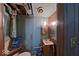 This bathroom has blue-painted walls, exposed piping, and vintage medicine cabinets at 3432 Joan Pl, Indianapolis, IN 46226