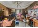This living room has wood-paneled walls, a sofa covered with items, and a ceiling fan at 3432 Joan Pl, Indianapolis, IN 46226