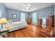Cozy bedroom with hardwood floors, ceiling fan, light blue walls, and natural light from the window at 3515 Guilford Ave, Indianapolis, IN 46205