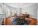 Elegant dining room with large windows, chandelier, wood floors, and stylish dining table at 3515 Guilford Ave, Indianapolis, IN 46205
