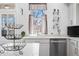 Sunlit kitchen features a large sink, stainless steel dishwasher, and decorative shelving at 3515 Guilford Ave, Indianapolis, IN 46205