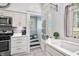 Cozy kitchen with white cabinets, modern appliances, and adjacent stairs at 3515 Guilford Ave, Indianapolis, IN 46205