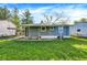 View of the home's light blue siding and covered porch with grassy lawn in the backyard at 3538 Cecil Ave, Indianapolis, IN 46226