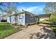 View of light blue single-story home with a carport, lush green grass, and a tidy exterior at 3538 Cecil Ave, Indianapolis, IN 46226