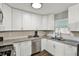 Contemporary kitchen with white cabinetry, stainless steel sink, and mosaic backsplash detail at 3538 Cecil Ave, Indianapolis, IN 46226