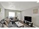 Bright living room featuring a comfortable gray sofa, modern decor, and dark wood flooring at 3538 Cecil Ave, Indianapolis, IN 46226