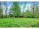 Lush backyard featuring a well-manicured lawn, mature trees, and a storage shed at 3875 Arrowhead Ct, Greenfield, IN 46140