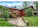 Multi-level wood deck and stairs lead to a red two-story home surrounded by lush greenery and blue skies at 3875 Arrowhead Ct, Greenfield, IN 46140