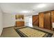 A finished basement including a kitchenette, sliding door to the yard, and wood paneled accent wall at 3875 Arrowhead Ct, Greenfield, IN 46140
