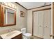 Clean bathroom with a sink, toilet, medicine cabinet, and a large closet with louvered doors at 3875 Arrowhead Ct, Greenfield, IN 46140