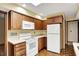 Well-lit kitchen featuring ample storage, wood cabinets, white appliances, and a practical layout at 3875 Arrowhead Ct, Greenfield, IN 46140