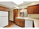 Charming kitchen features wood cabinets, neutral countertops, and a bright window view at 3875 Arrowhead Ct, Greenfield, IN 46140