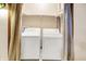 A laundry room featuring a white washer and dryer, beige shelving and a privacy curtain at 3875 Arrowhead Ct, Greenfield, IN 46140
