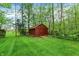 Storage shed nestled among mature trees, featuring a well-maintained lawn at 3875 Arrowhead Ct, Greenfield, IN 46140