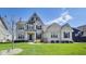Charming two-story home with a well-manicured lawn, elegant brickwork, and striking architectural details under a bright blue sky at 3997 Spylaw Rd, Bargersville, IN 46106