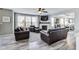 Comfortable living room with dark brown sofas, a fireplace, a ceiling fan, and large windows with white curtains at 3997 Spylaw Rd, Bargersville, IN 46106