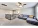 Open living room area boasts plush carpet, a comfortable blue sectional sofa, and a ceiling fan at 3997 Spylaw Rd, Bargersville, IN 46106