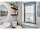 Chic powder room with a modern sink, decorative shelves, and a stylish mirror at 3997 Spylaw Rd, Bargersville, IN 46106