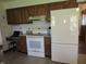 This kitchen has wood cabinets, a white range, and a matching white refrigerator at 4166 Cobblestone Way, Greenwood, IN 46143