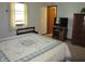 Comfortable main bedroom with a patterned quilt, window and wooden furnishings at 4166 Cobblestone Way, Greenwood, IN 46143