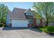 Charming home with a lush green lawn, a mature tree, brick accents, and an attached two car garage at 419 Old Glory Dr, Greenfield, IN 46140