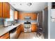 Well-equipped kitchen featuring stainless steel appliances, tile floors, ample counter space, and wood cabinetry at 419 Old Glory Dr, Greenfield, IN 46140