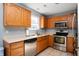 Well-lit kitchen featuring stainless steel appliances, tile floors, ample counter space, and wood cabinetry at 419 Old Glory Dr, Greenfield, IN 46140