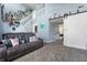 Comfortable living room featuring plush carpeting, light blue walls, sliding barn door, and staircase at 419 Old Glory Dr, Greenfield, IN 46140