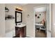 Bathroom with vanity sink, mirror, modern lighting, and an open doorway at 4260 Springwood Trl, Indianapolis, IN 46228