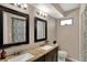 Spacious bathroom with double sinks, dark wood cabinetry, and large mirrors at 4260 Springwood Trl, Indianapolis, IN 46228