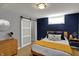 Bedroom with white sliding door, blue accent wall, wood dresser, wood floors at 4260 Springwood Trl, Indianapolis, IN 46228