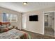 Bedroom with carpet, neutral decor, and a mounted TV near a hallway entrance at 4260 Springwood Trl, Indianapolis, IN 46228