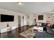 Spacious living room with dark hardwood floors, a large sofa, and stairs at 4260 Springwood Trl, Indianapolis, IN 46228