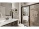 Bathroom with a tiled shower, a glass door, a framed mirror, and a white porcelain sink at 4428 Voyageur Way, Carmel, IN 46074