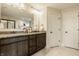 Well-lit bathroom features double sinks, granite countertops, and stylish dark wood cabinetry at 4428 Voyageur Way, Carmel, IN 46074