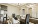 Open dining room with dark wood floors, six chairs, and an open doorway to the kitchen at 4428 Voyageur Way, Carmel, IN 46074