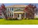 Rear exterior of two-story home featuring a covered patio and well-maintained lawn at 4428 Voyageur Way, Carmel, IN 46074