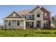 Charming two-story home with stone and siding, landscaped front yard, and inviting entryway at 4428 Voyageur Way, Carmel, IN 46074