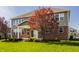 Back exterior of home with a covered patio, large windows, and green lawn at 4428 Voyageur Way, Carmel, IN 46074