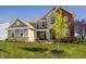 A charming two-story home with a well-manicured lawn, landscaping, and a stone and brick facade at 4428 Voyageur Way, Carmel, IN 46074